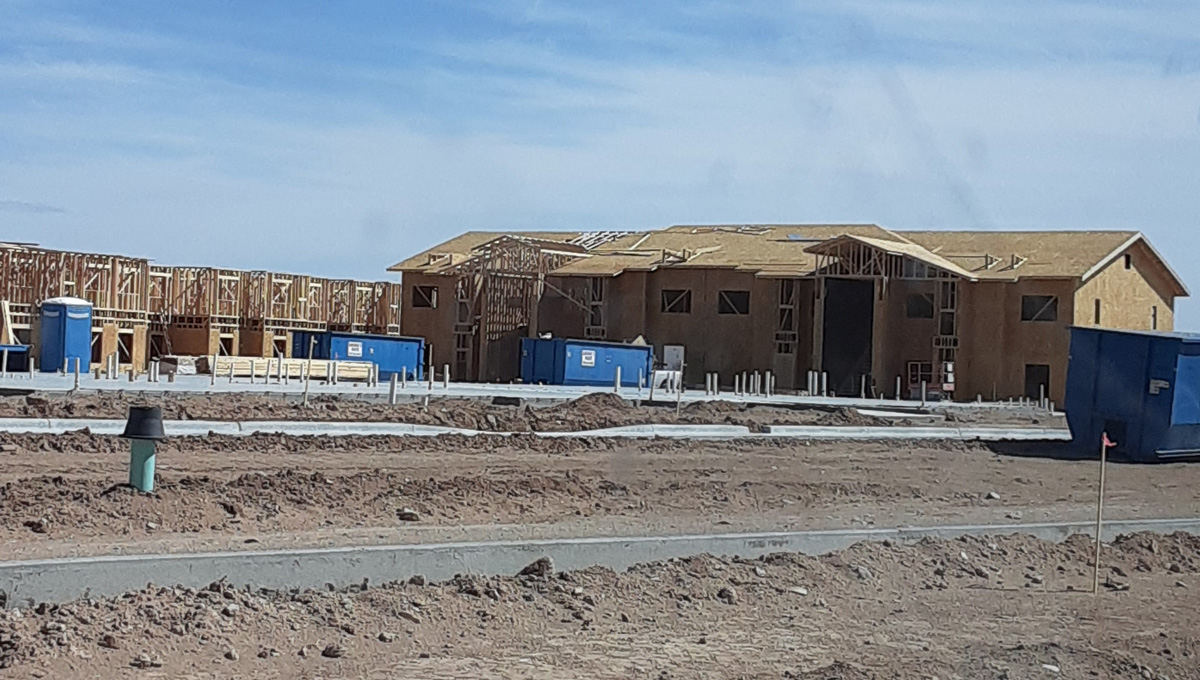A construction site with multiple blue Sarabia’s roll-off containers in El Paso.