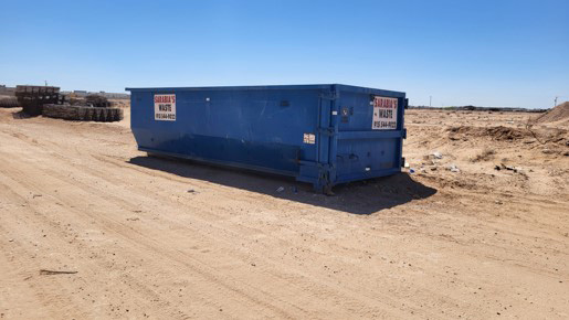 A blue roll-off dumpster at a construction site in El Paso.